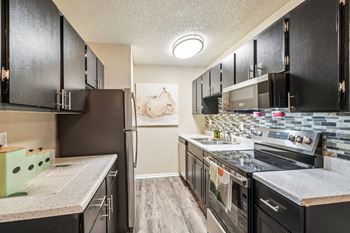 A kitchen with black cabinets and a white countertop